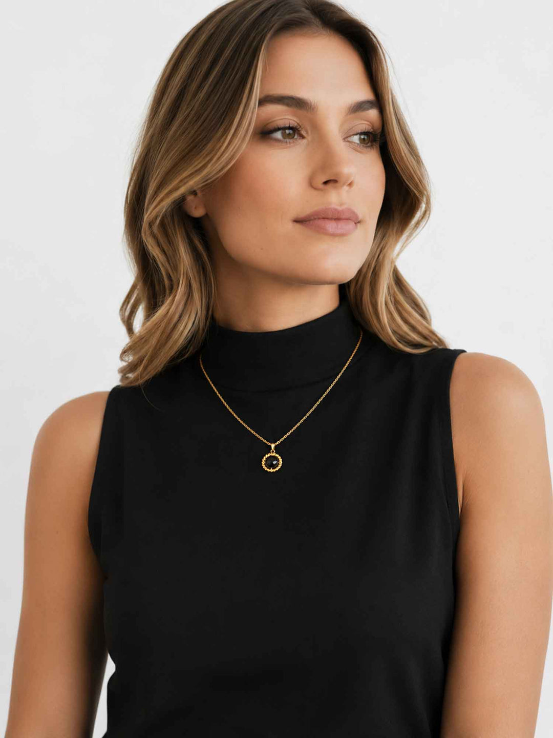 Model wearing Melina black acrylic gold pendant necklace with black outfit