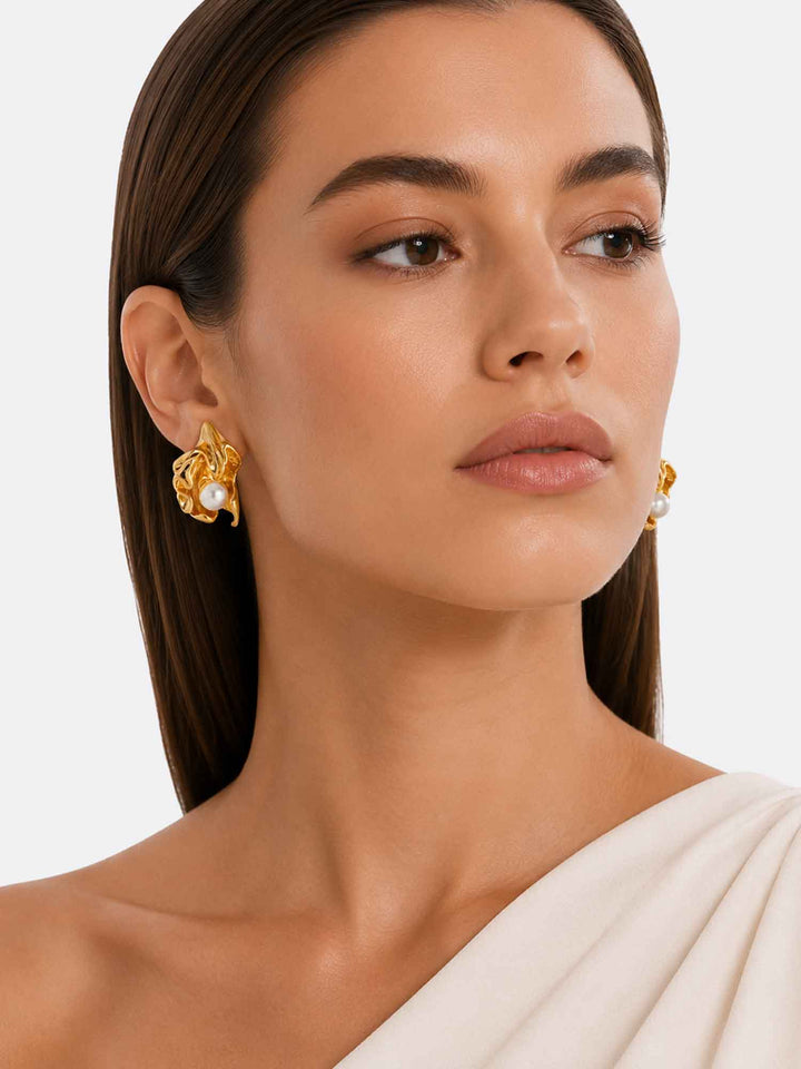 Model wearing Minette sculptural pearl gold stud earrings with elegant styling