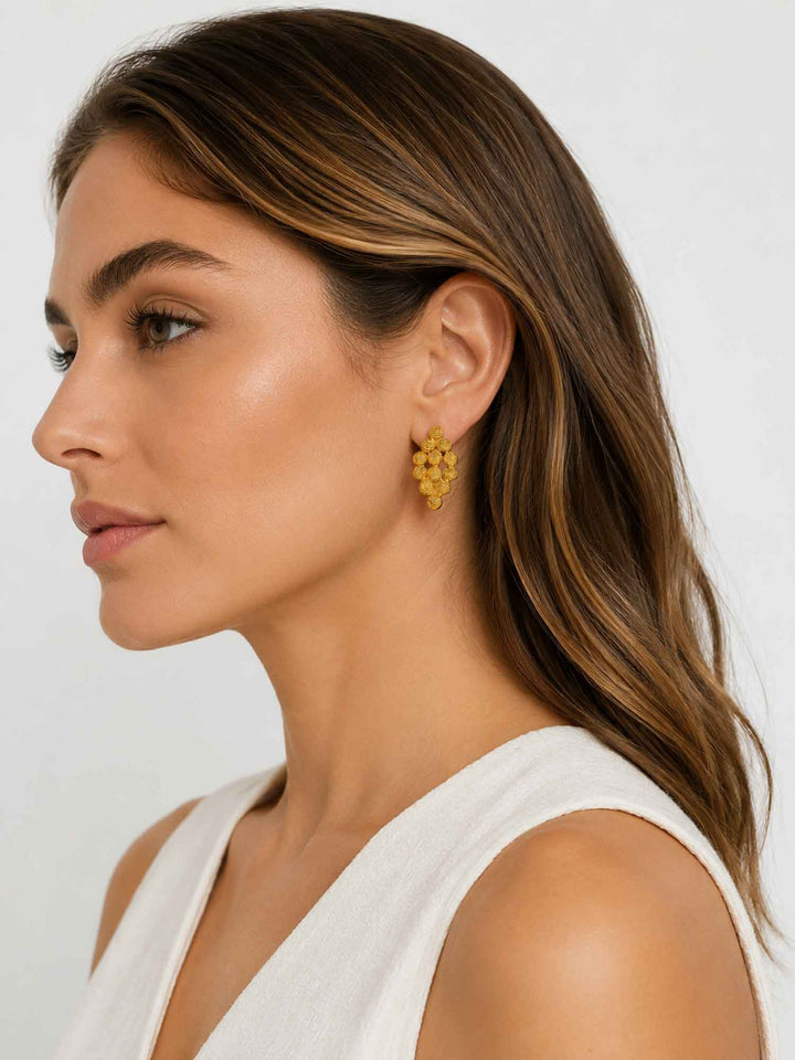 Side view of model wearing Nicola textured gold cluster stud earrings