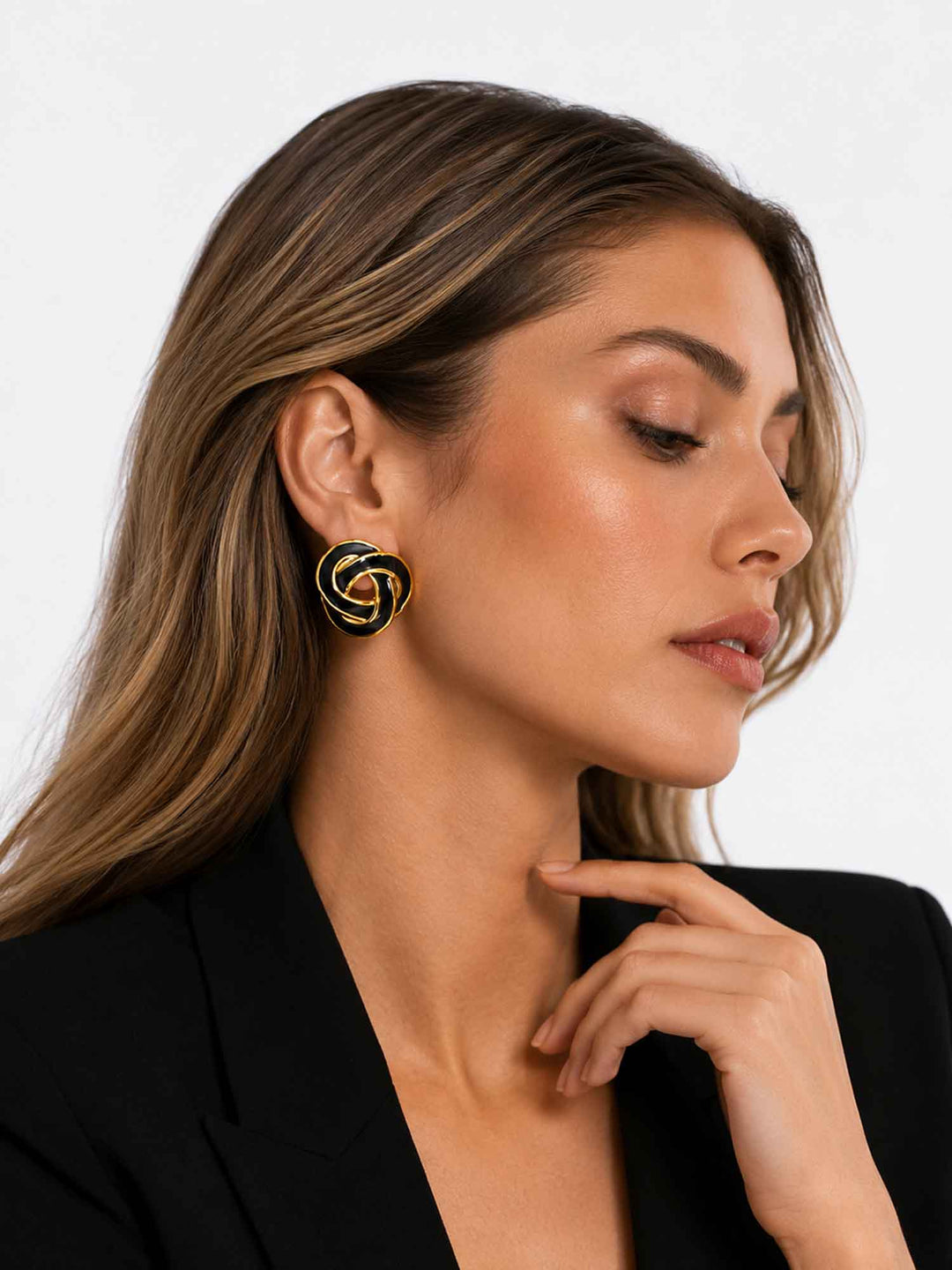 Model wearing Nimah black enamel knot stud earrings with elegant evening styling
