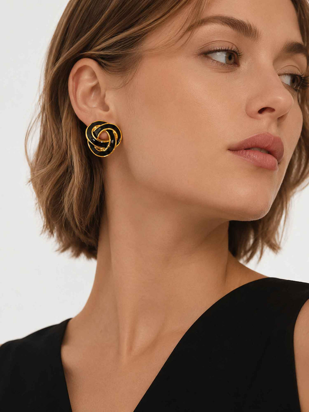 Side view of model wearing Nimah black enamel knot stud earrings