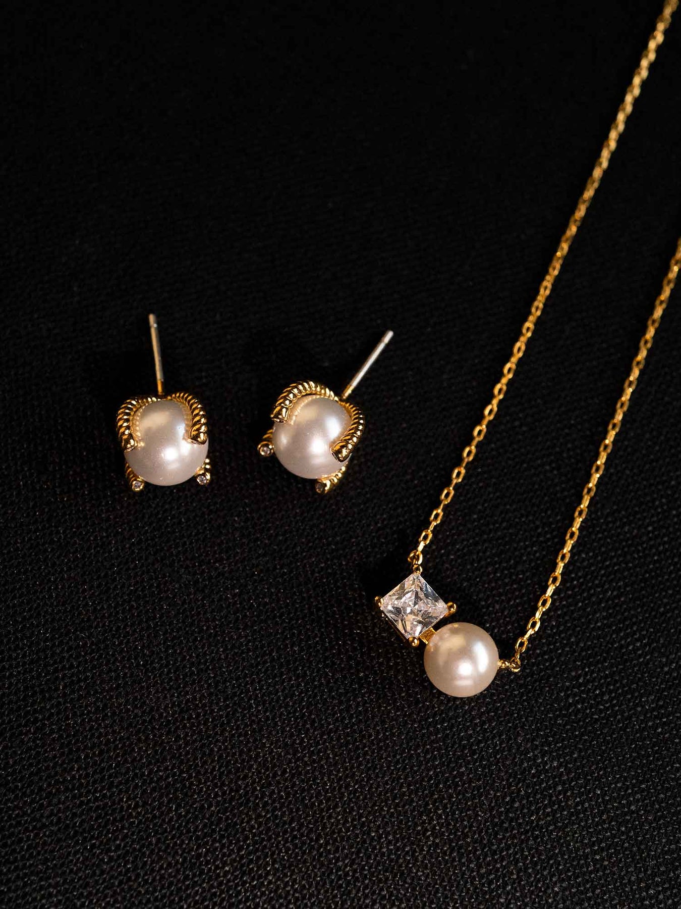Nuala glass pearl stud earrings styled with matching pearl necklace on dark background