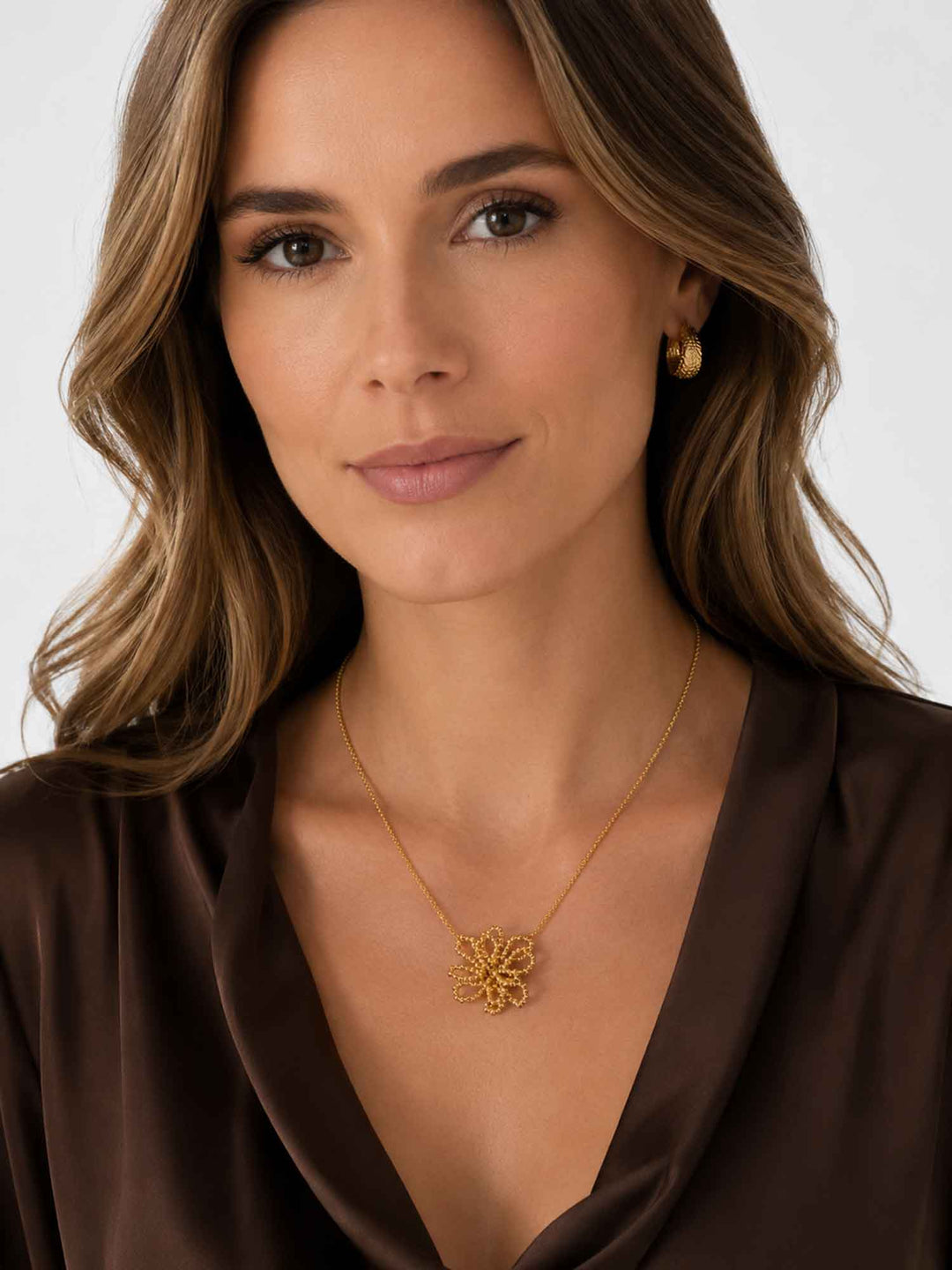Model wearing Olyssa beaded flower gold pendant necklace with elegant dark styling