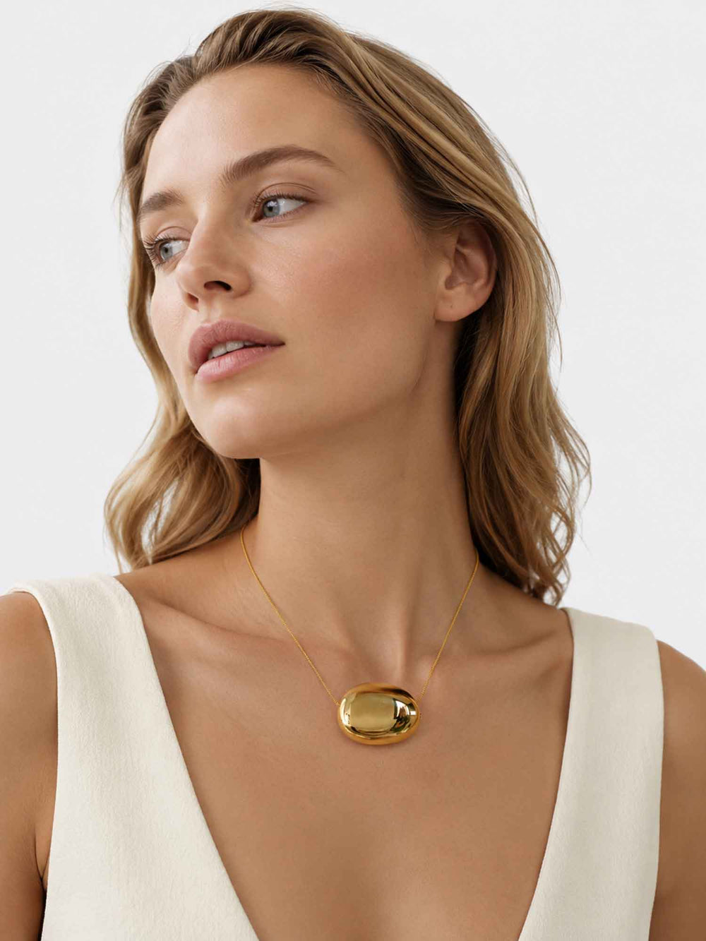 Model wearing Paulina gold dome pendant necklace with elegant styling