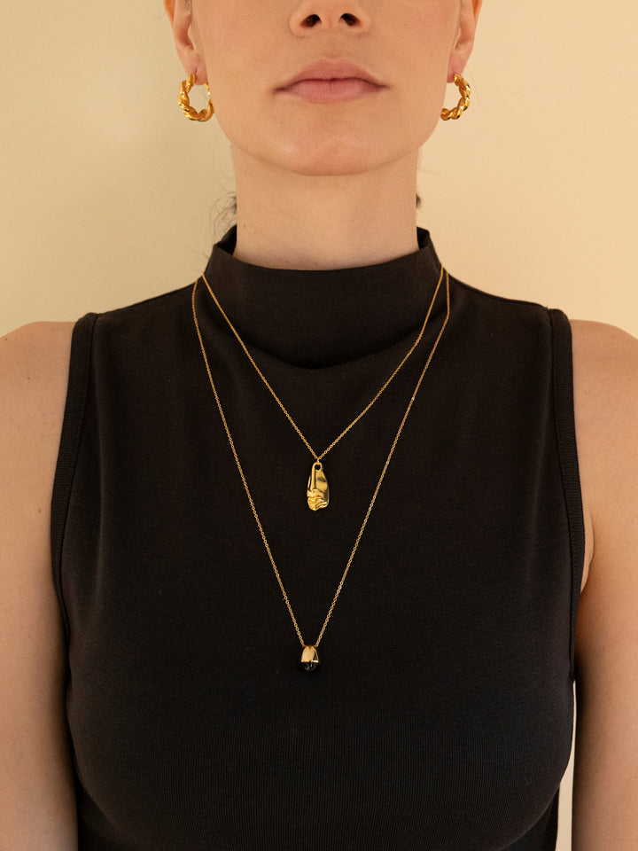 Renira black onyx gold pendant necklace styled with layered necklaces