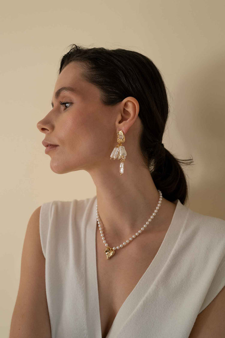 Side view of model wearing Samira baroque pearl drop earrings