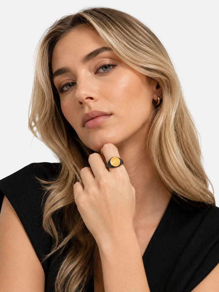 Model wearing Timara black enamel gold signet ring with elegant styling