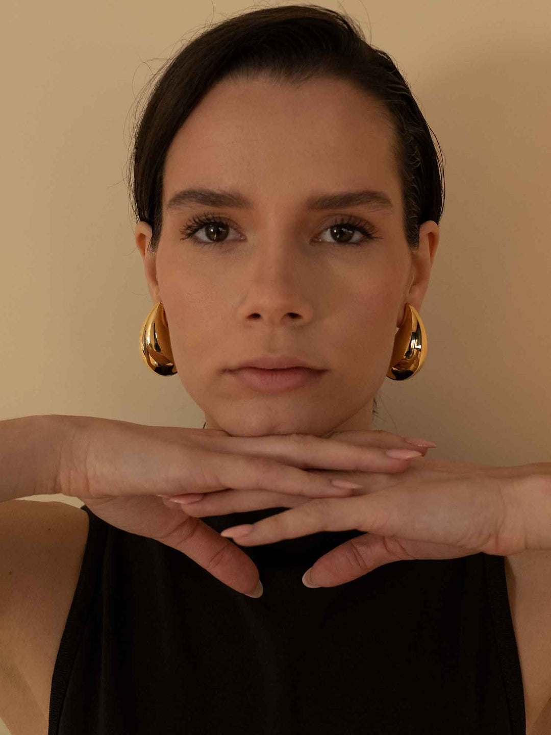 Model wearing Titania large gold teardrop earrings with statement styling