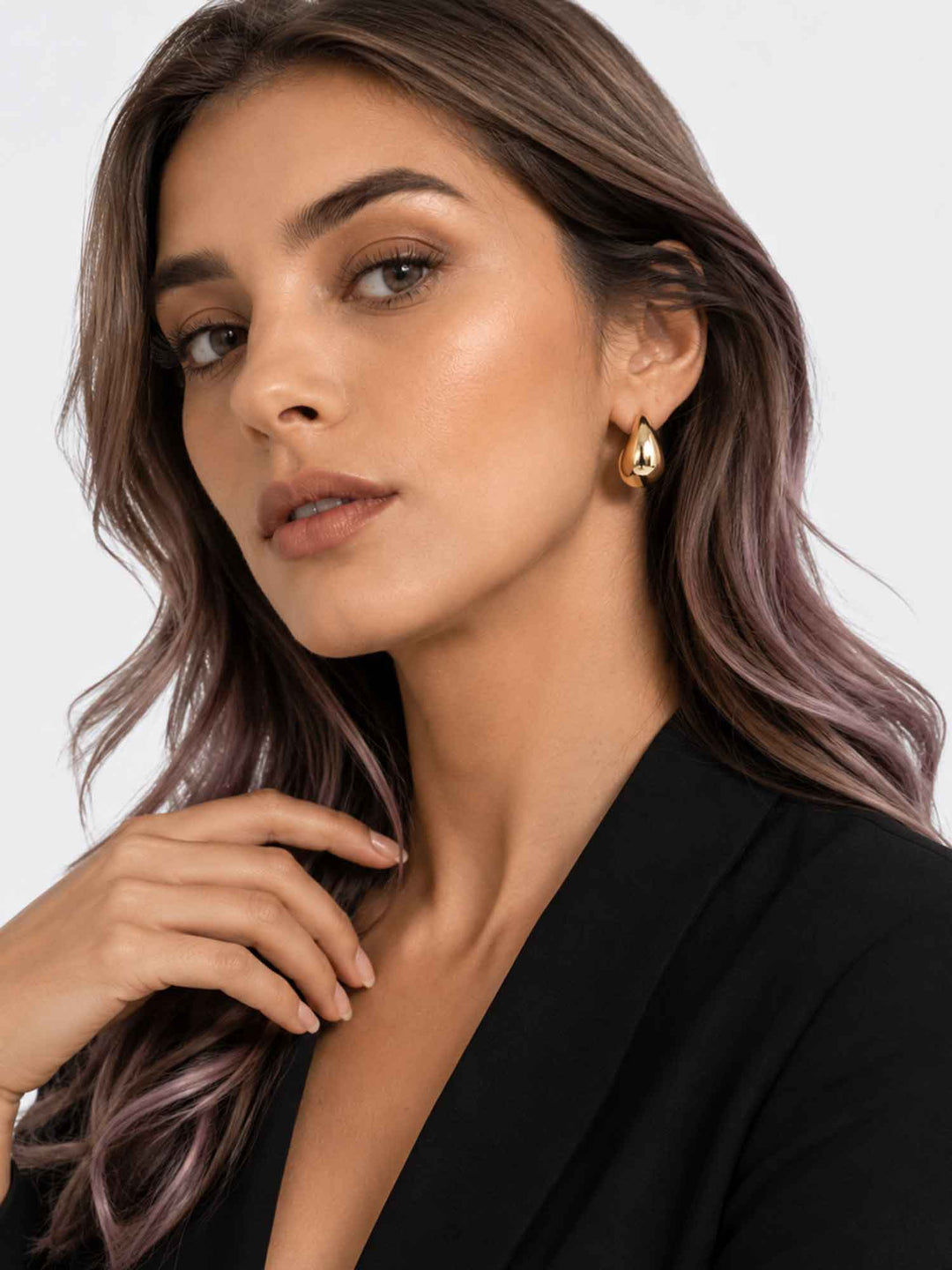 Model wearing Titania small gold teardrop earrings with a polished everyday look