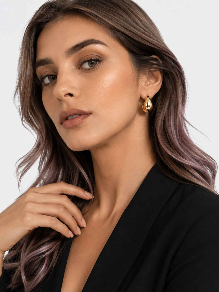 Model wearing Titania small gold teardrop earrings with a polished everyday look