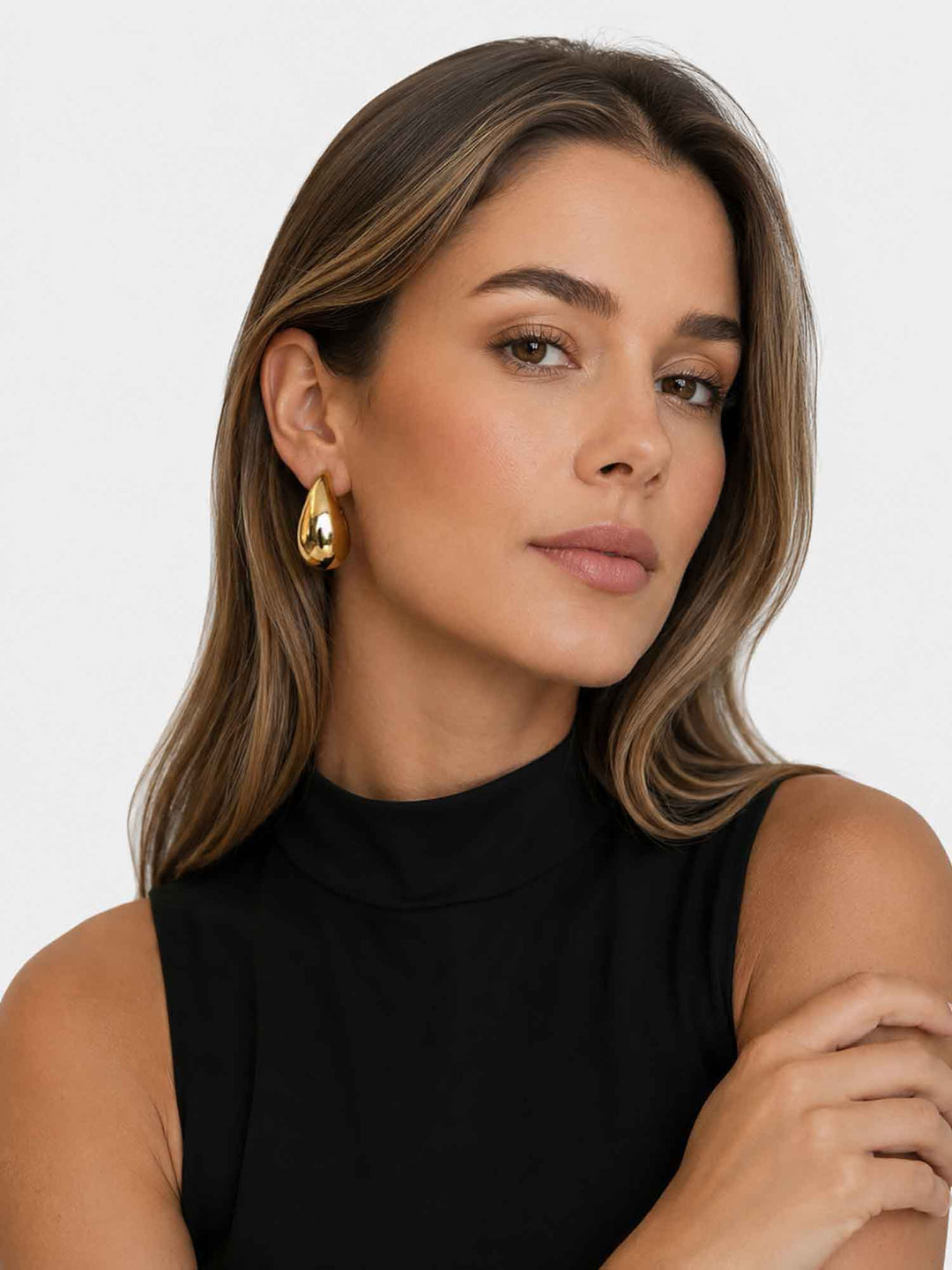 Model wearing Titania medium gold teardrop earrings with black top styling