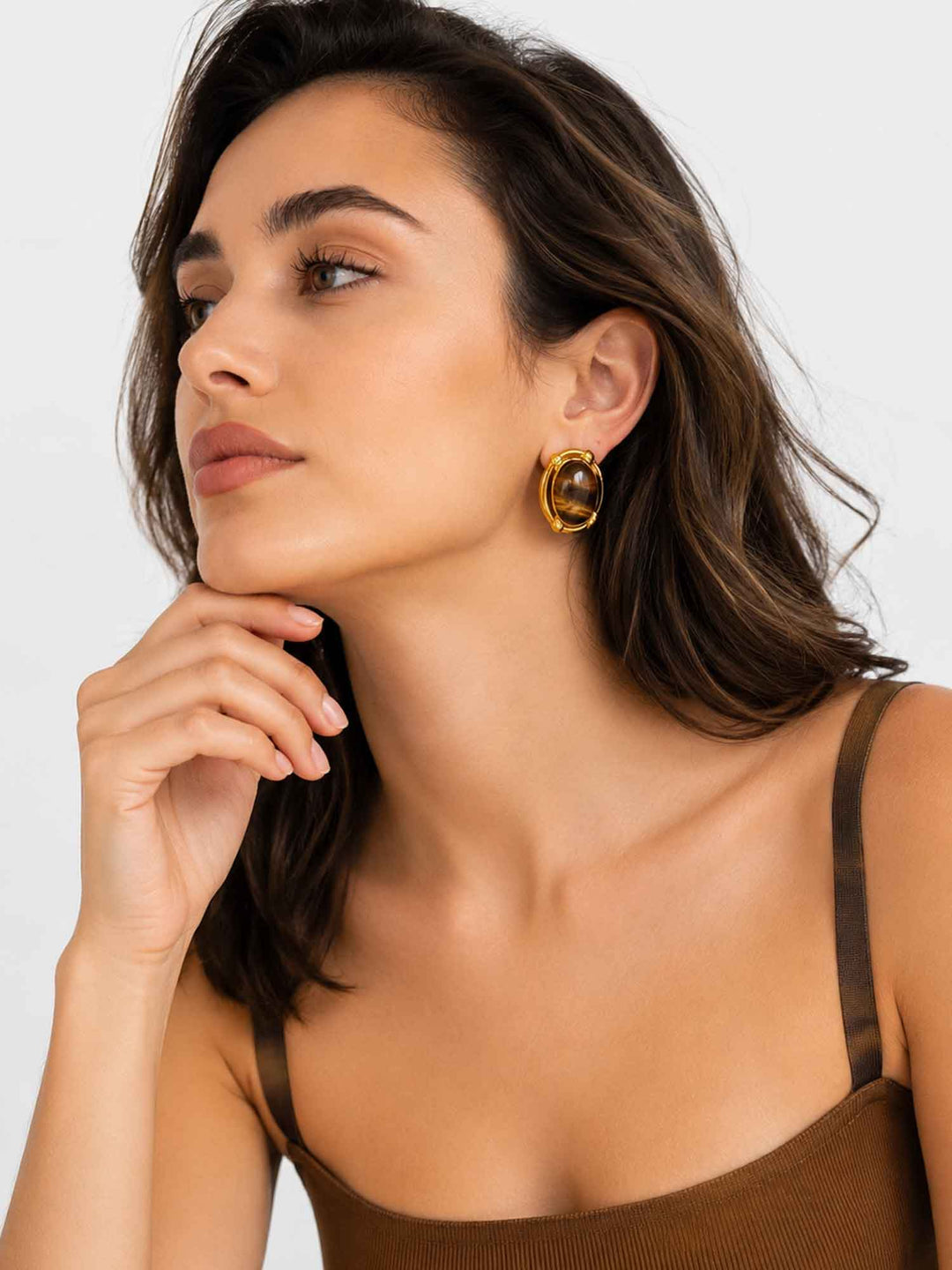 Close-up view of model wearing vintage-inspired tiger eye stone gold stud earrings