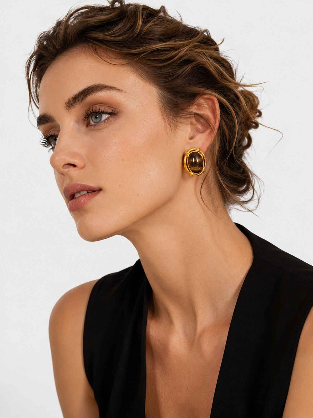 Model wearing vintage-inspired tiger eye stone gold stud earrings with elegant styling