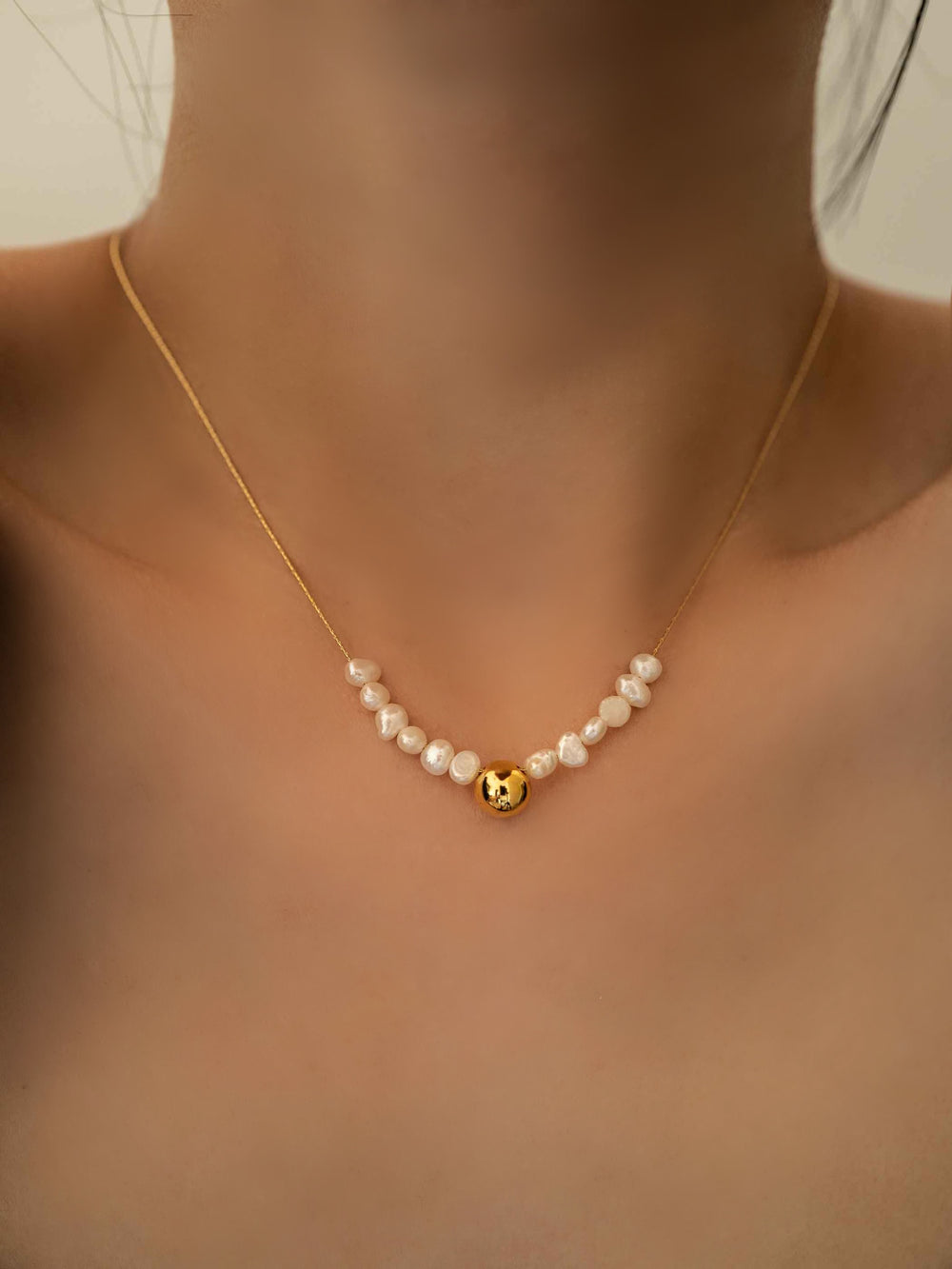 Modelo con collar de perlas de agua dulce cultivadas en cuentas doradas bañadas en 18K