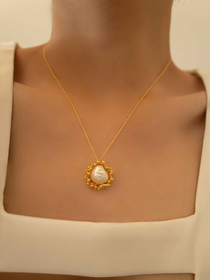Una modelo luce un collar en forma de puesta de sol con perlas barrocas