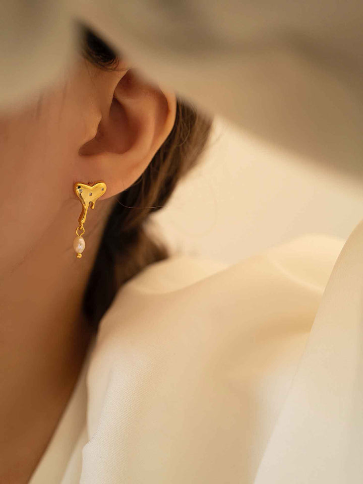 Modelo femenina con pendientes de corazón de perlas